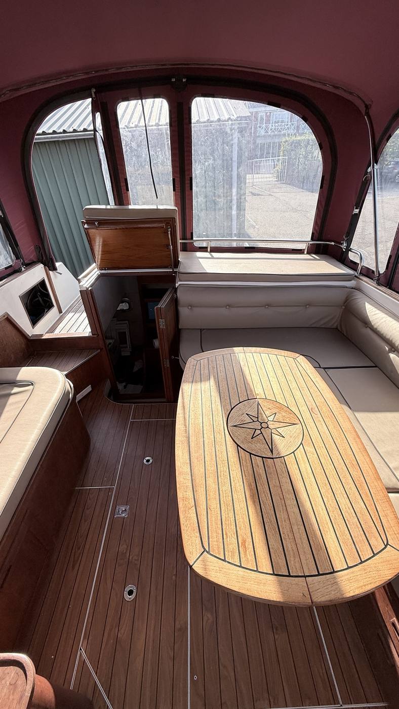 Interieur van de kajuit van de boot, met teakhouten tafel